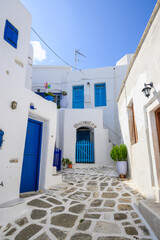Typical Greek house with blue windows and doors on whitewashed street in beautiful Lefkes village on Paros island. Cyclades, Greece