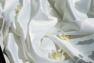 Fototapeta na wymiar White silk fabric and flowers
