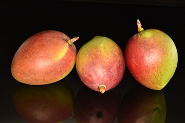 ripe organic mango, close-up, on a black background.