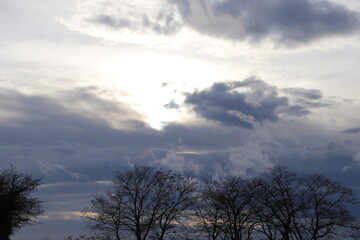 Fototapeta na wymiar Ciel nuageux laissant transparaître le soleil, ville de Corbas, département du Rhône, France