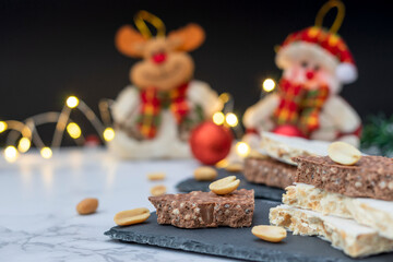 Traditional Spanish sweet - turrón, on a table with lights and Christmas decorations