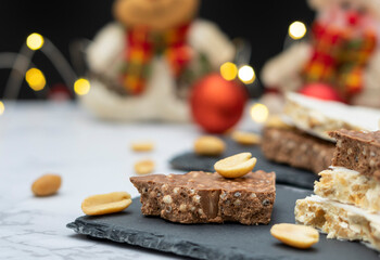 Traditional Spanish sweet - turrón, on a table with lights and Christmas decorations