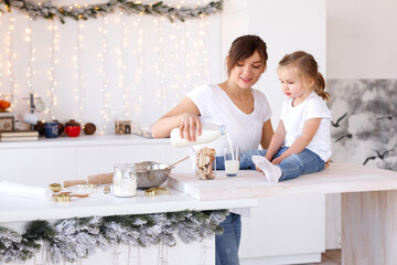 Obraz na płótnie Canvas Mom pours her daughter's milk from bottle
