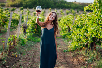 beautiful woman in dress with a glass of wine at a picnic in the vineyard
