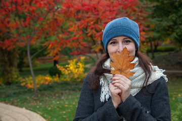 Pretty brunette in white scarf in autumn park