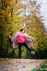 Ballerina dancing in nature among autumn leaves.