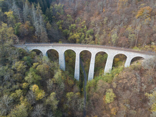 Aerial top view of stone Railway Viaduct near Prague, Czech republic. Old Czech railway line. Vintage arch bridge during autumn season.