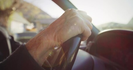 Close up, elderly man's hand on steering wheel