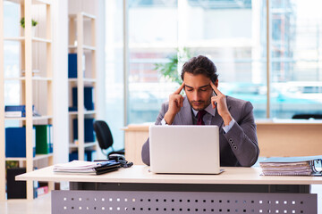 Fototapeta premium Young male employee working in the office