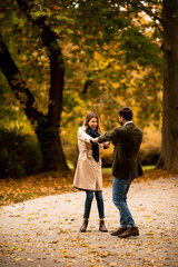 Fototapeta premium Young couple having fun in the autumn park
