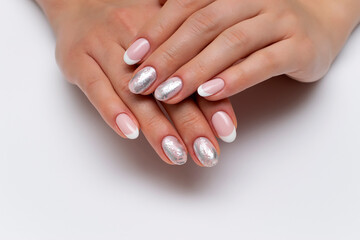 Fototapeta premium wedding french white manicure with silver decor, matte foil on short oval nails close-up on a white background.