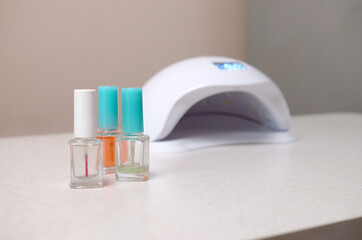 UV diode lamp lights for nails and set of cosmetic nail polish for manicure and pedicure on white...