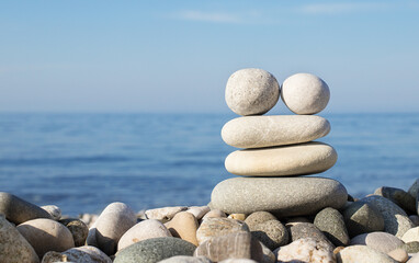 Fototapeta na wymiar Pyramid of balanced stones on the background of the sea. Selective focus