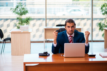 Young handsome employee working in the office