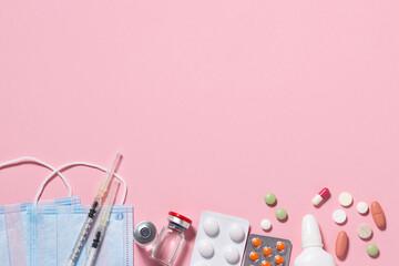 Set of medical supplements such as facial masks, tablets, pills, vials and syringes on pink pastel background. Flu season concept. Health care and treatment concept.