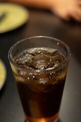 Cola with Ice Cubes. Glass of cola with ice cubes on wood table, soft drink. Copy Space.
