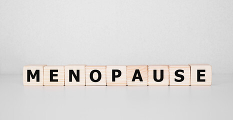 Menopause word written on wood block. menopause text on table, concept.