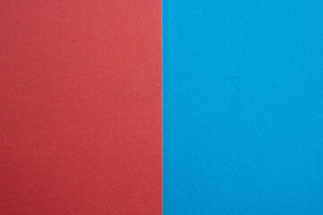 A close-up of blue suede and red is divided in half by the ratio of the textured background, the separation of fabrics