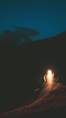 Un coche ilumina una carretera de alta montaña en una noche estrellada