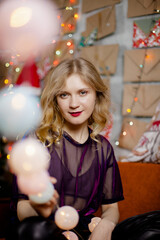 Close portrait of a cute lady with Christmas lights, looking at the camera