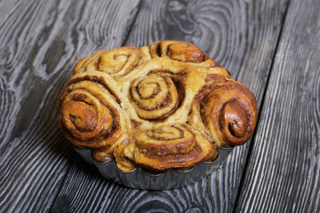 Baked cinnabons in shape. Stand on black composite boards. Close-up shot.