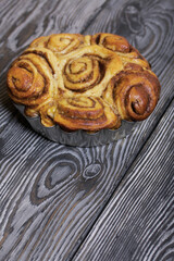 Baked cinnabons in shape. Stand on black composite boards. Close-up shot.