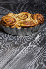 Baked cinnabons in shape. Stand on black composite boards. Close-up shot.