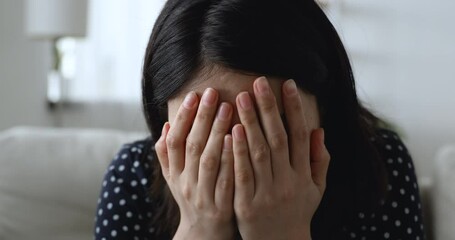 Close up head shot stressed desperate young korean vietnamese mixed race woman covering face with hands, suffering from strong headache or feeling nervous alone at home having psychological problems. - Powered by Adobe