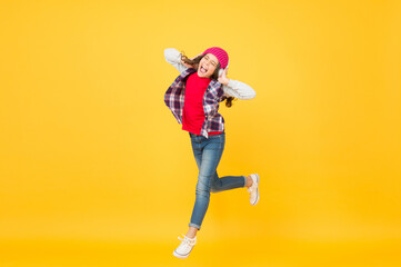Fototapeta na wymiar Let the music take you away. Energetic girl move to music. Little kid enjoy singing yellow background. Headphones technology. Modern life. Happy dance. Play the moment