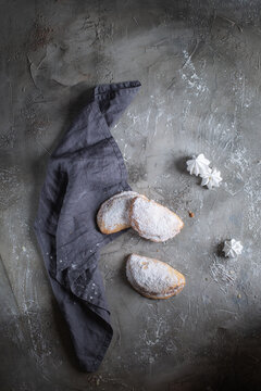 fresh baked goods in powdered sugar on wooden background