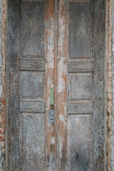 Old shabby, cracked door with sprinkled paint. The door is a hundred years old.