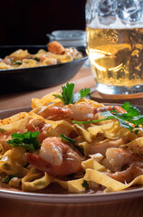 glass of beer and pasta with shrimps