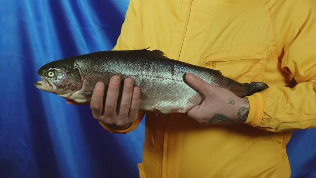 Cool fisherman holding a big fish in his hands. Colorist video.