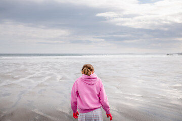 Girl on beach in spring in Maine