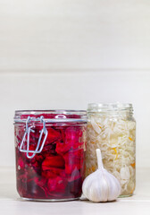 Homemade Sauerkraut with Carrot and Salad Cabbage with Beetroot on a wooden table. Fermented food. Copy space.