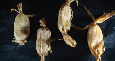 Tamales en un plano cenital sobre una tabla oscura
