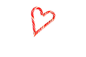 Two red striped candy canes of Santa are stacked in the shape of a heart on white background. Isolate, frame. Christmas, new year, Valentine's day, winter holiday atmosphere for lovers and loved ones