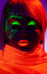 Close-up portrait of a female model with amazing colorful neon makeup, and orange scarf on neck.