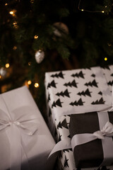 New Year's gifts are under the tree. Large white gift boxes. Beautiful Christmas tree in toys.
