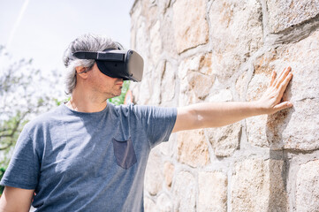 Male wearing virtual reality goggles on the street.Technology concept