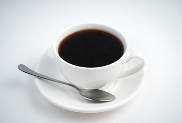 A Cup of coffee and a saucer with a spoon on a light background. Side view. Coffee background.