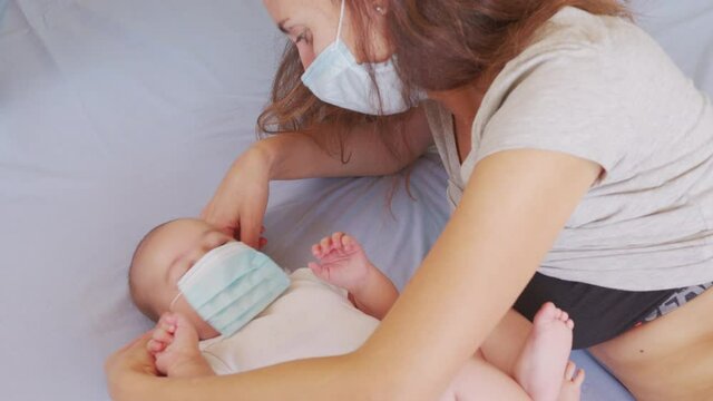Mom puts on her little child a medical mask. Close-up.
