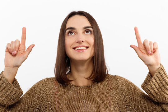 Close-up portrait pretty young woman pointing with two fingers, looking at camera , isolated on white background