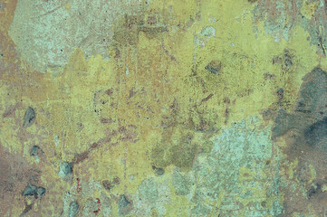 A large fragment of the yellow clay wall of the old house with cracks and roughness, exfoliating part of the plaster. Vintage background. Rough flushed texture. Space to copy text.