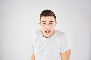 Fototapeta premium Man in a white t-shirt emotions gestures with hands close-up cropped view light background