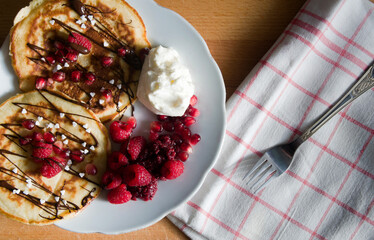 Delicious pancakes served with fruit, raspberries and pomegranate
