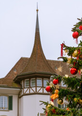 Christmas in Switzerland. Decorated Christmas tree on the background of a building in the Swiss city of Thun
