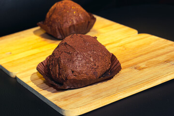 Two delicious handmade chocolate truffles on a wood cutting board