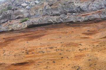 grey rock behind brown sand