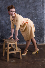 Cheerful middle aged woman dressed in beige dress studio portrait.